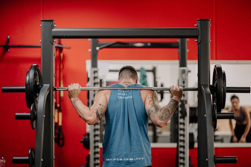 ragazzo che si allena in palestra alle spalle compr